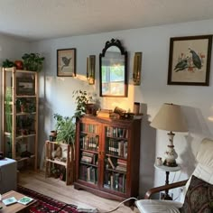 a living room filled with furniture and bookshelves next to a wall mounted mirror