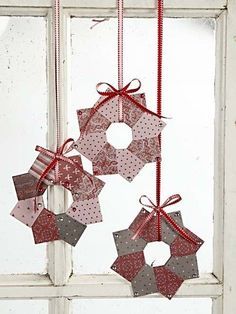 some ornaments hanging from a window sill in front of a white door with red ribbon