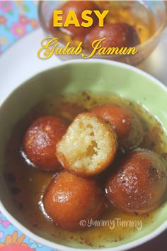 some food is in a green bowl on a colorful table cloth with the words easy gulab jamun