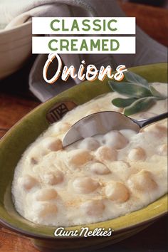 a green bowl filled with oatmeal on top of a wooden table next to a spoon