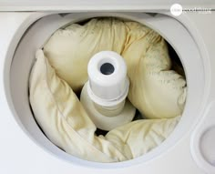 an open washing machine with some bags in it