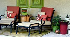 two chairs and a table on a patio with potted plants