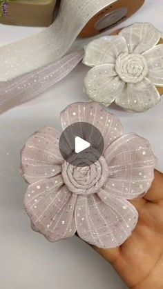 someone is holding some fabric flowers in their hand and they are being used to make crafts