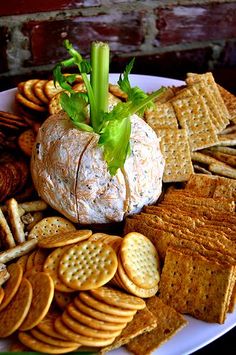 a cheese ball surrounded by crackers on a plate