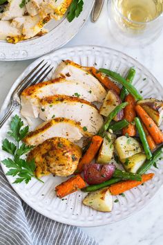 two plates with chicken and vegetables on them