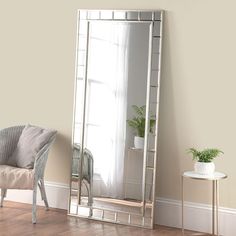 a mirror sitting on top of a wooden floor next to a chair