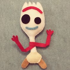 a white and red stuffed animal with black eyes on it's head, arms and legs