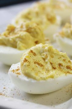 deviled eggs with cinnamon sprinkles sit on a white plate