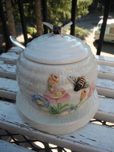 a ceramic jar sitting on top of a wooden bench