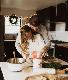 a man and woman are preparing food in the kitchen