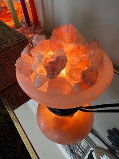 a bowl filled with lots of ice on top of a table next to some candles