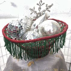 a basket filled with silver disco balls on top of a table