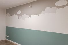 an empty room with painted clouds on the wall