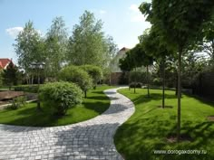 a brick path in the middle of a lush green park