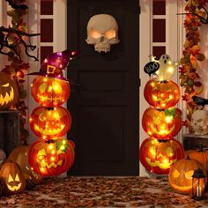 halloween decorations with pumpkins and jack - o'- lanterns in front of a door