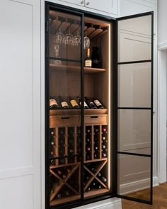 a wine cabinet with several bottles and glasses in it