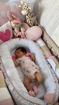 a baby sleeping in a crib with stuffed animals