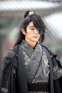 a man with long black hair wearing a kimono