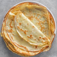 a plate filled with pancakes on top of a table next to a knife and fork