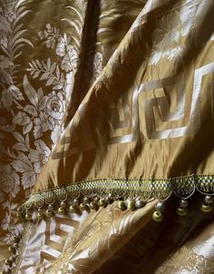 a close up view of a curtain with beaded trim and tassels on it