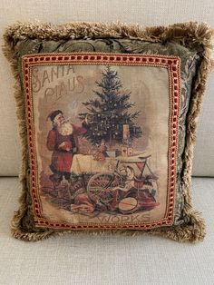 an old fashioned christmas pillow with santa claus and his bike on it's side