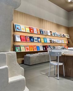 a room filled with lots of books next to a white table and chair in front of a book shelf