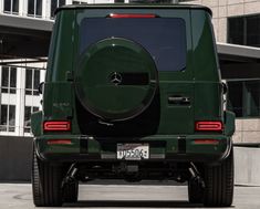 the rear end of a green mercedes g class