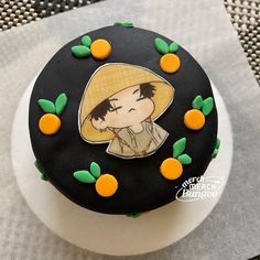 there is a black cake with oranges on it that has a drawing of a girl wearing a hat