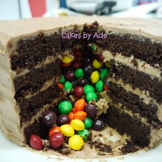 a cake with chocolate frosting and candy candies on the inside is cut in half