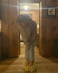 a woman standing on top of a wooden floor