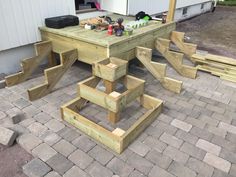 a wooden picnic table sitting on top of a brick patio