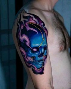 a man with a blue and purple skull tattoo on his left upper arm, next to a mirror