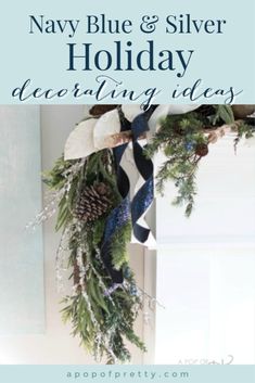 a christmas wreath with pine cones and blue and white ribbon hanging from the front door