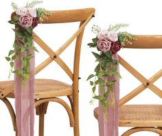 two wooden chairs decorated with pink flowers and greenery, one is made out of wood