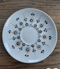 a white plate with blue and brown designs on it, sitting on a wooden table