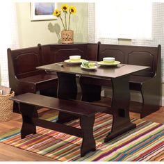 a kitchen table with two benches in front of it and a rug on the floor