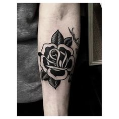 a black and white rose tattoo on the arm