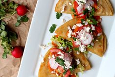 three tortillas with tomatoes, lettuce and feta cheese on them