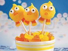 three yellow lollipops with googly eyes in a bowl