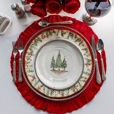 a christmas place setting with red roses and silverware