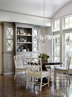 a dinning room table with chairs and a china cabinet in the back ground area