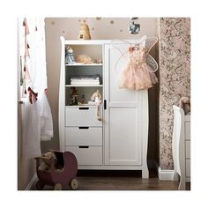 a baby's room with a white cabinet and pink wallpaper, teddy bear on the floor