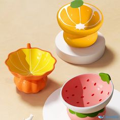 three colorful fruit shaped dishes sitting on top of a table next to eachother