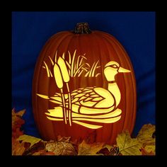 a carved pumpkin with a duck and reeds on it in front of some leaves