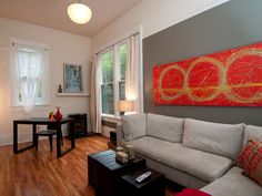 a living room filled with furniture and a painting on the wall