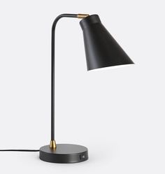 a black and gold lamp on a white background with the light turned off to show its dim lighting