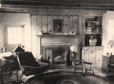 an old black and white photo of a living room with a fire place in it