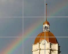 a clock tower with a rainbow in the background