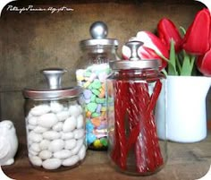 some jars with candy and flowers in them