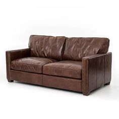 a brown leather couch sitting on top of a white floor